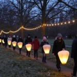 Families walking the winter lantern trail under string lights